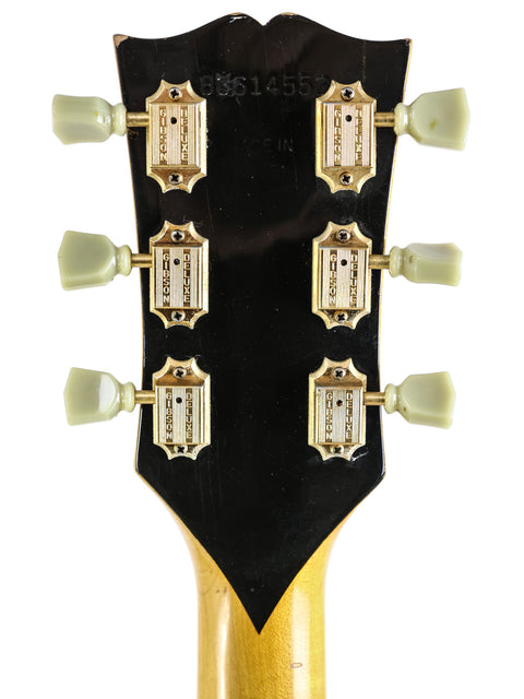 Detailed view of the gold-finished headstock of a vintage 1984 Gibson SJ-200 guitar.