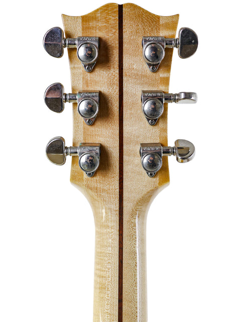 Detailed view of the headstock of a 2008 Gibson SJ-150 acoustic guitar, highlighting its elegant features and logo.