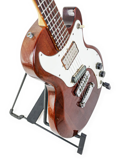 Display of a 1975 Vintage Gibson Marauder guitar on a stand, contrasted against a bright white background.
