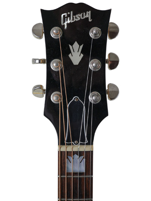 Displaying a Gibson Les Paul Custom Shop guitar, known for its quality, next to a 2008 Gibson SJ-150 acoustic model.