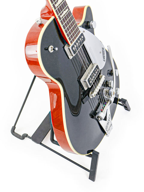 Elegant Gretsch Duo Jet 6128TSP 1957 Reissue guitar on a stand, highlighting its vintage charm with a crisp white background.
