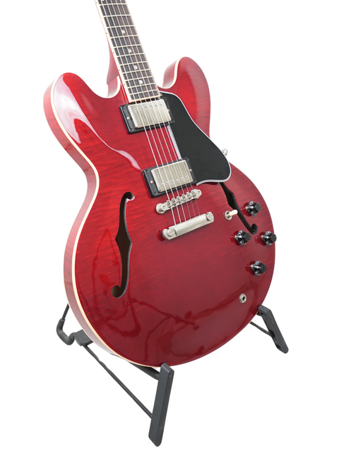 Eye-catching red Gibson ES-335 Dot electric guitar on a stand, representing quality and style in music since 2006.
