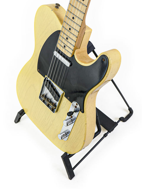 Fender Custom Shop 70th Anniversary Broadcaster guitar displayed on a stand with a white backdrop.
