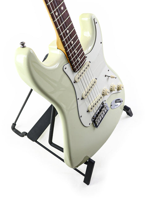 Fender Custom Shop Jeff Beck Signature Stratocaster in white, elegantly positioned on a black stand.