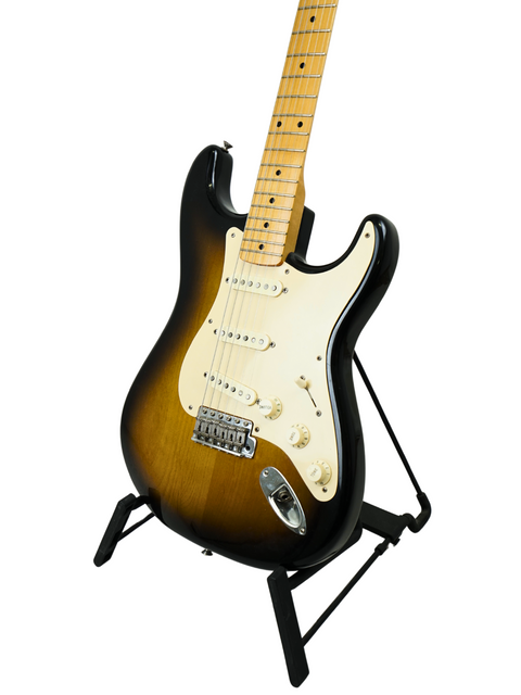 Fender Eric Johnson Signature Stratocaster guitar on a stand, featuring a sleek black body, model year 2005.