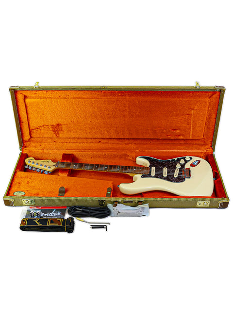 Fender Jeff Beck Signature Stratocaster, white guitar in an orange case, with a guitar pick placed next to it.