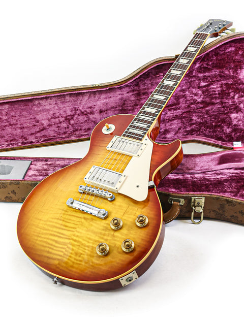 Gibson Custom Shop 1959 Reissue Les Paul R9 guitar alongside its case, emphasizing its iconic style and quality.
