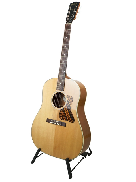 Gibson J-35 guitar on a stand, elegantly displayed against a clean white background, showcasing its classic design.