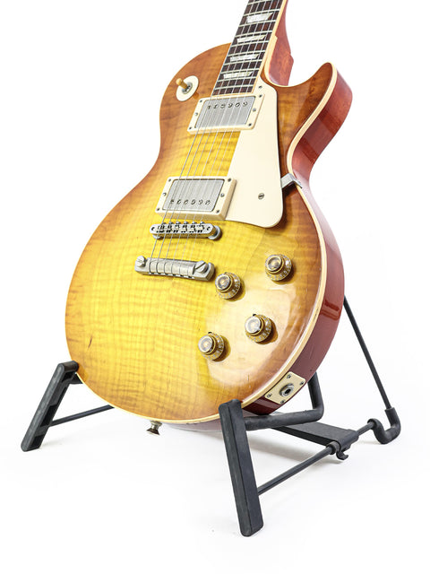 Gibson Les Paul '59 Reissue guitar displayed on a stand, featuring a striking white background that highlights its beauty.