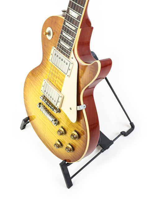 Gibson Les Paul '59 Reissue guitar from 2009 rests elegantly on a stand, showcasing its classic design and craftsmanship.