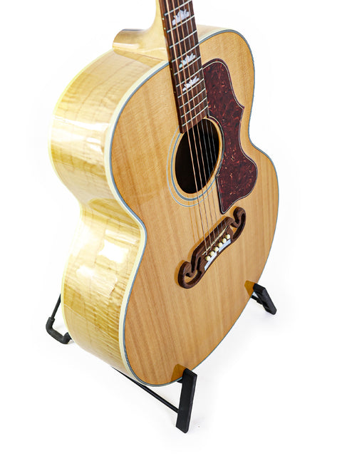 Gibson SJ-150 guitar on a stand against a clean white background, showcasing its elegant design and craftsmanship.