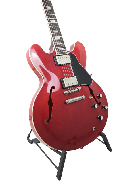 Gorgeous red electric guitar on a stand, the Gibson ES-335 Block '63 Reissue, perfect for collectors and performers alike.