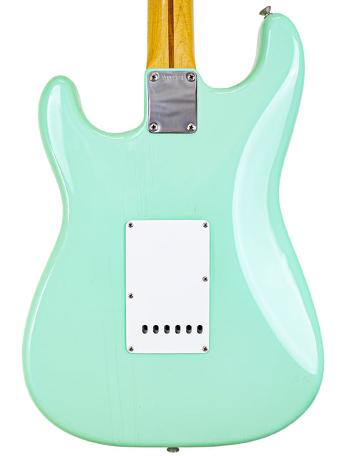 Green electric guitar, a 1985 Fender AVRI ‘57 Stratocaster, featuring a stylish white pickguard.