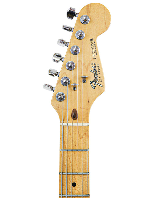 Headstock and neck of a Fender Stratocaster guitar on a white background.
