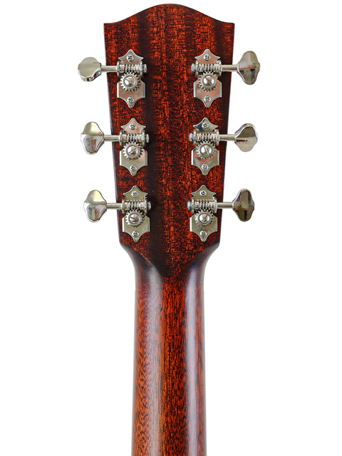Headstock of a guitar with tuning pegs on a red wood grain background.