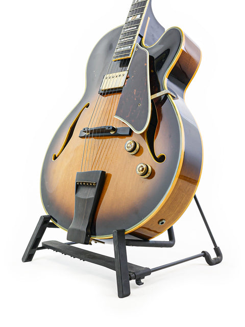 Ibanez JP20 Joe Pass Signature guitar displayed on a stand, set against a stark white background, highlighting its classic features.
