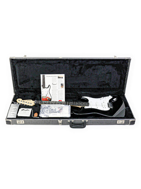 Inside a black guitar case lies a 1993 Fender Strat Plus Ultra, highlighting its iconic shape and rich color.
