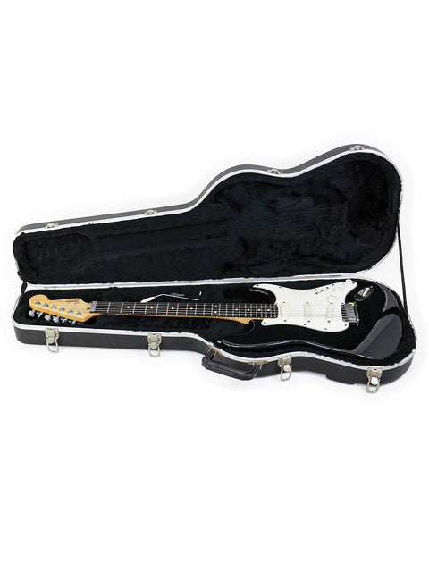Inside a black guitar case lies a white Fender Strat Plus guitar, model year 1991, highlighting its classic appeal.