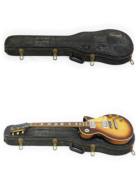 Inside a case, two guitars are featured, prominently including a 1979 Gibson Les Paul Standard.