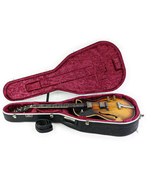 Inside a guitar case, a 1962 vintage Gibson ES-175D rests, representing a piece of musical history and artistry.
