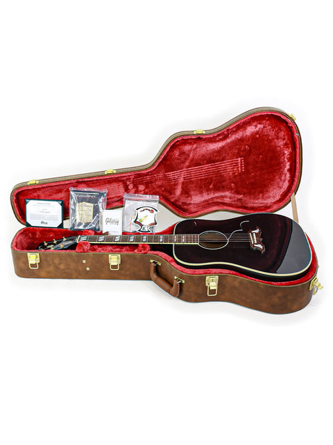 Inside a guitar case, a Gibson Custom Shop Elvis Dove from 2023 rests, highlighting its unique features and artistry.
