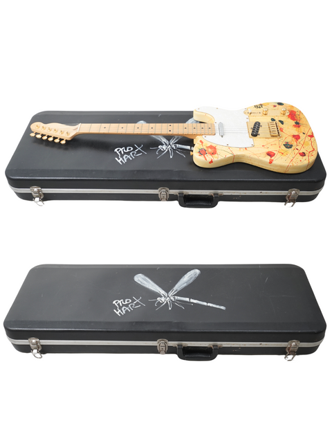 Inside a guitar case, a Pro Hart Telecaster and a knife rest together, highlighting a cool mix of artistry and utility.