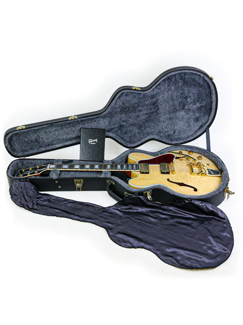 Inside a guitar case lies a stunning gold Gibson Custom Shop ES-355, USA-made in 2011, highlighting its luxurious finish.