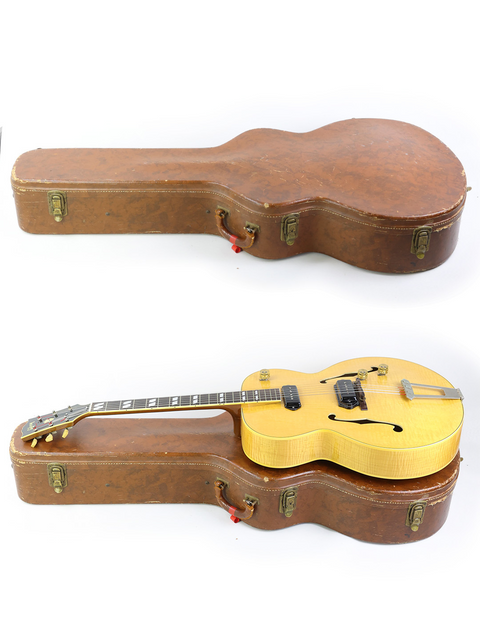 Inside a wooden case, two guitars rest, prominently featuring a 1952 Gibson ES-300, a true vintage gem.