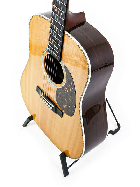 Martin HD-28 guitar from 2006 resting on a stand with a plain white backdrop.