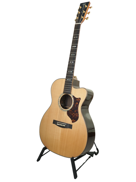 Martin OMC-PA1 guitar from 2011 displayed on a stand, set against a clean white background.