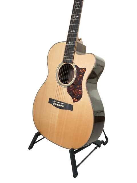 Martin OMC-PA1 guitar on a stand against a clean white background, showcasing its elegant design and craftsmanship.
