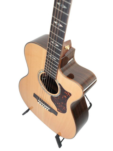 Martin OMC-PA1 guitar with a wooden body rests on a sleek black stand, showcasing its elegant design from 2011.