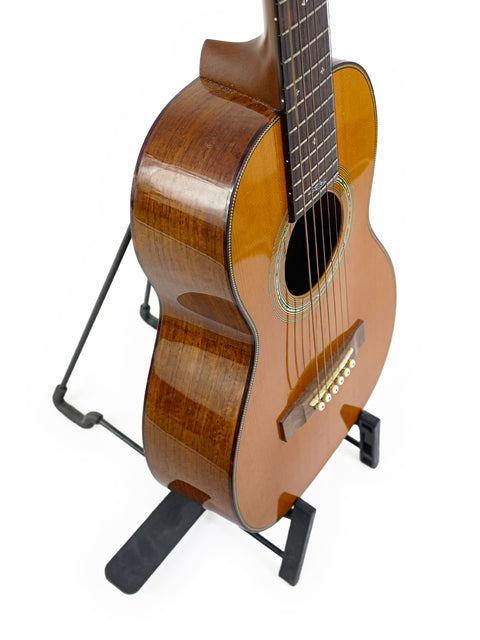 Martin Sting Mini Signature Edition guitar #35 of 100 on a stand, displayed on a clean white background.