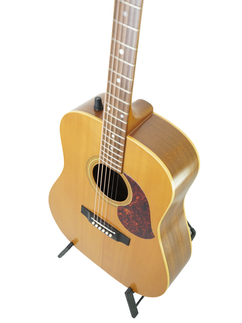 Maton EM300 guitar on a stand against a clean white background, showcasing its natural finish and elegant design.