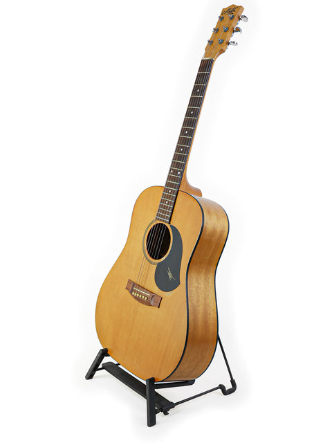 Maton M225 guitar, made in Australia in 1996, resting on a stand with a bright white background.