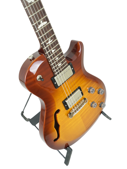 PRS S2 Singlecut Semi-Hollow guitar in sunburst finish, elegantly positioned on a stand, highlighting its craftsmanship.
