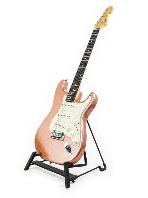  Pink Fender Custom Shop American Classic Stratocaster guitar displayed on a stand with a white backdrop.

