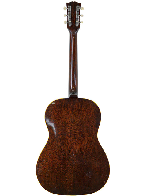 Rear perspective of a vintage Gibson LG-1 acoustic guitar from 1954, emphasizing its elegant wood finish.