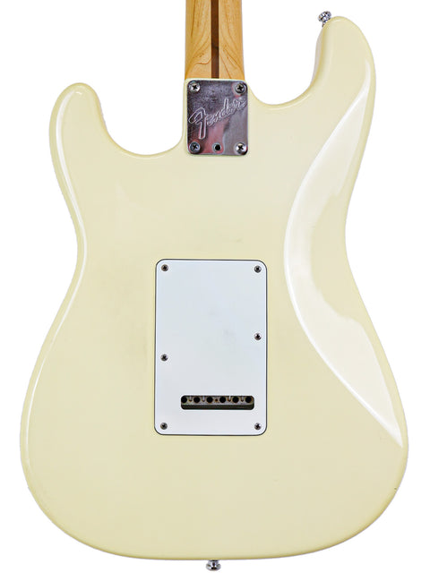 Rear view of a cream-colored Fender electric guitar body with neck and output jack.