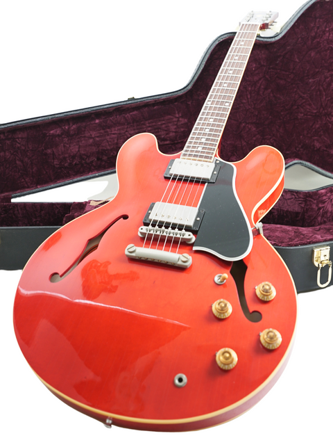 Red Gibson Custom ES-335 Aged '59 Reissue guitar displayed in its case, highlighting its classic style and quality.