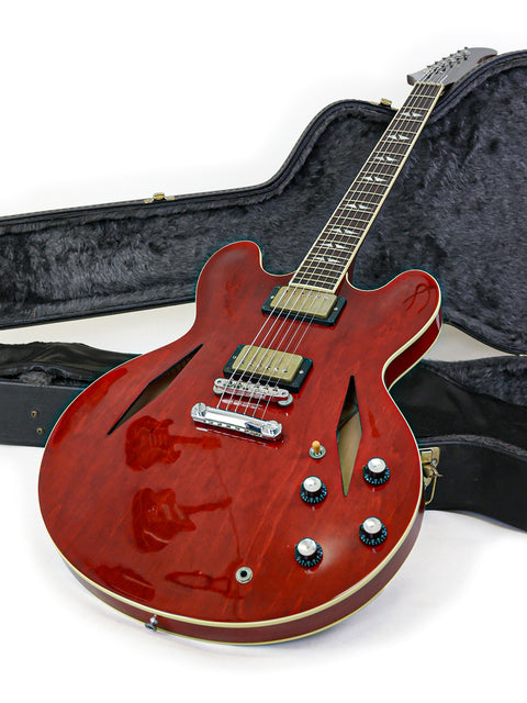 Red Gibson Custom Shop Trini Lopez guitar in a case on a white surface, showcasing its elegant design and craftsmanship.