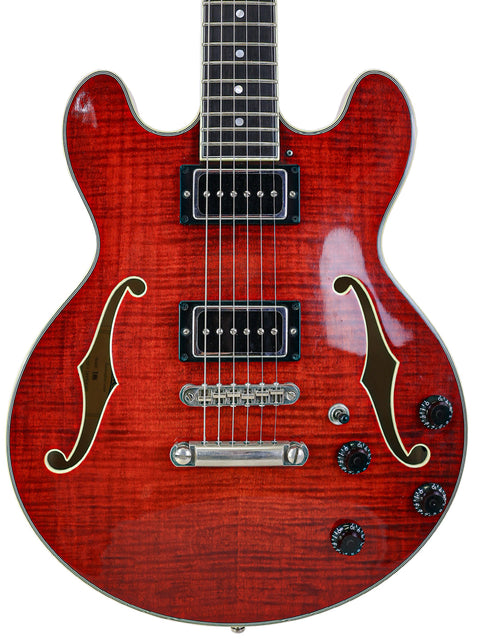 Red semi-hollow electric guitar with dual humbuckers and f-holes.