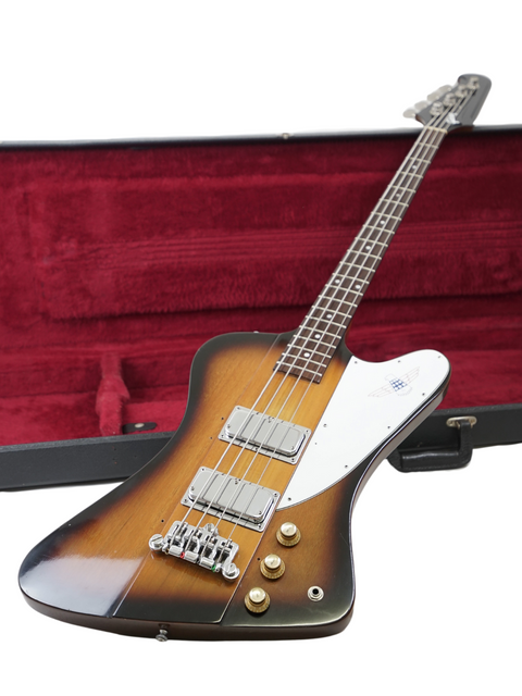Showcasing a 1976 vintage Gibson Bicentennial Thunderbird IV Bass with its case, alongside a beautiful guitar.