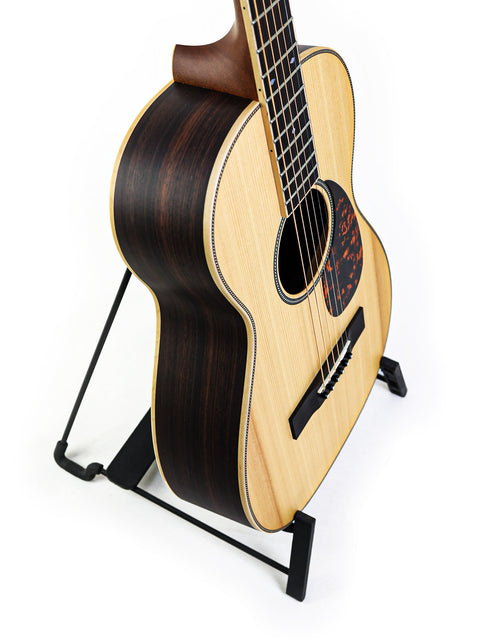 Small acoustic guitar, Larrivée 0-40R from 2016, displayed on a stand for easy viewing.