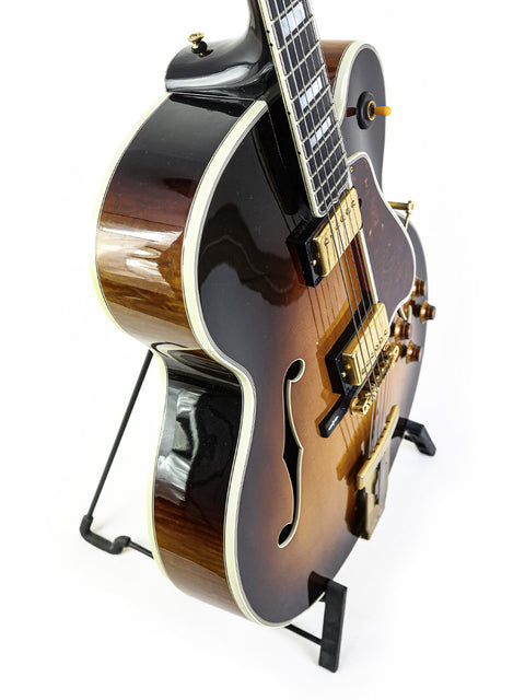 Stunning Gibson L-5 CES guitar from 2002 resting on a stand, highlighting its beauty and musical heritage.
