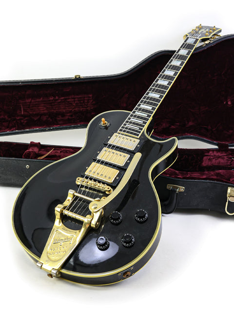 Stunning black and gold Gibson Les Paul Custom B3 guitar from 2004, displayed with its protective case.
