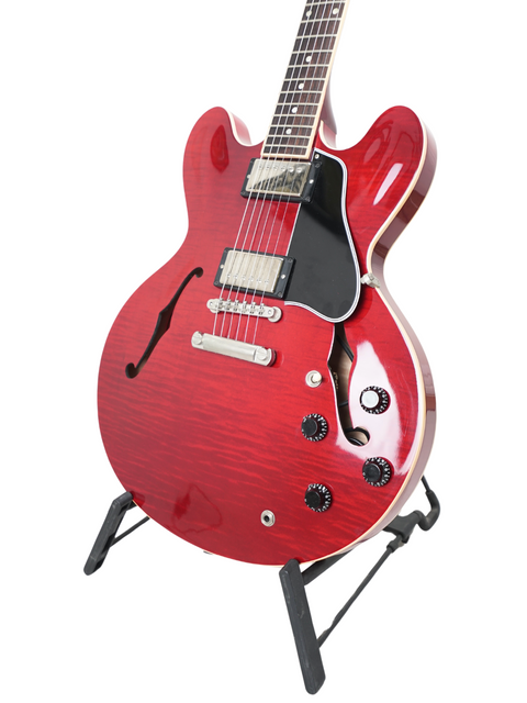 Stunning red Gibson ES-335 Dot electric guitar displayed on a stand, highlighting its classic style and craftsmanship from 2006.
