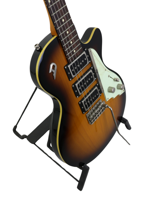 Sunburst electric guitar on a black stand with dual pickups and white pickguard.