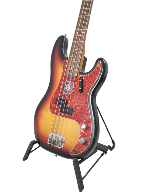 Sunburst electric guitar resting on a stand, isolated on a white background.