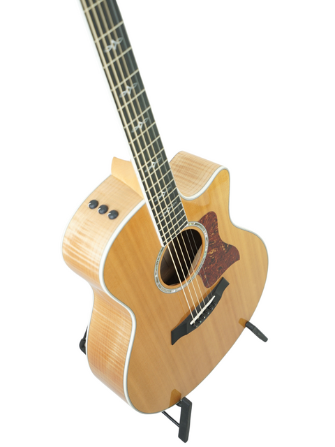 Taylor 616ce guitar from 2011 resting on a stand, set against a bright white backdrop.